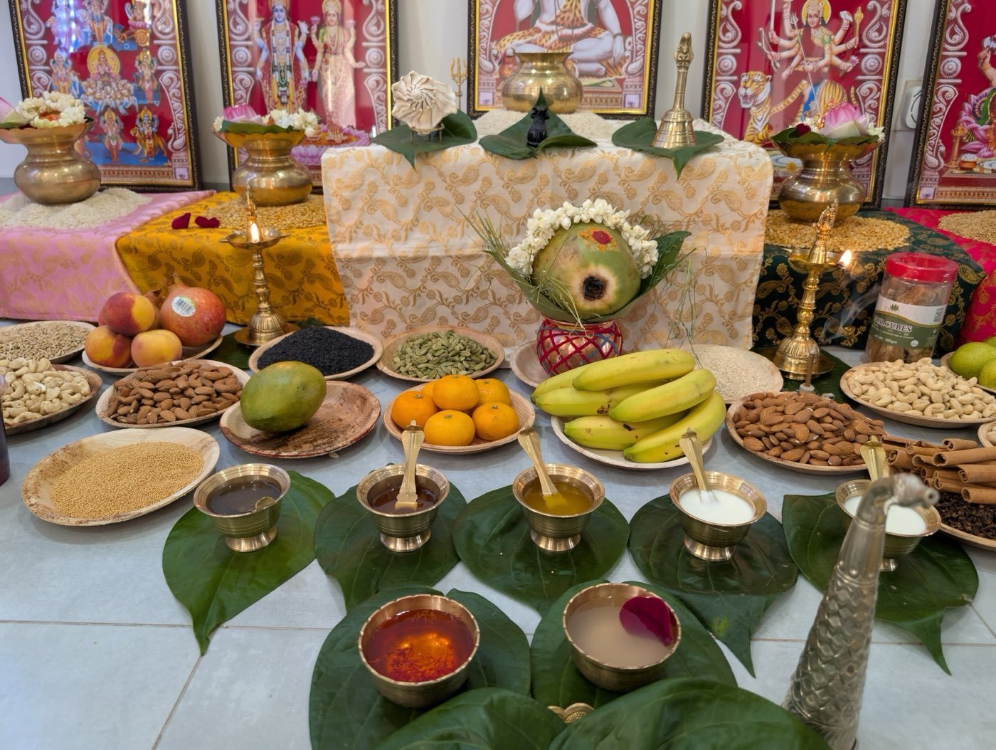 Rows of offerings, fruit and lamps laid out for a puja